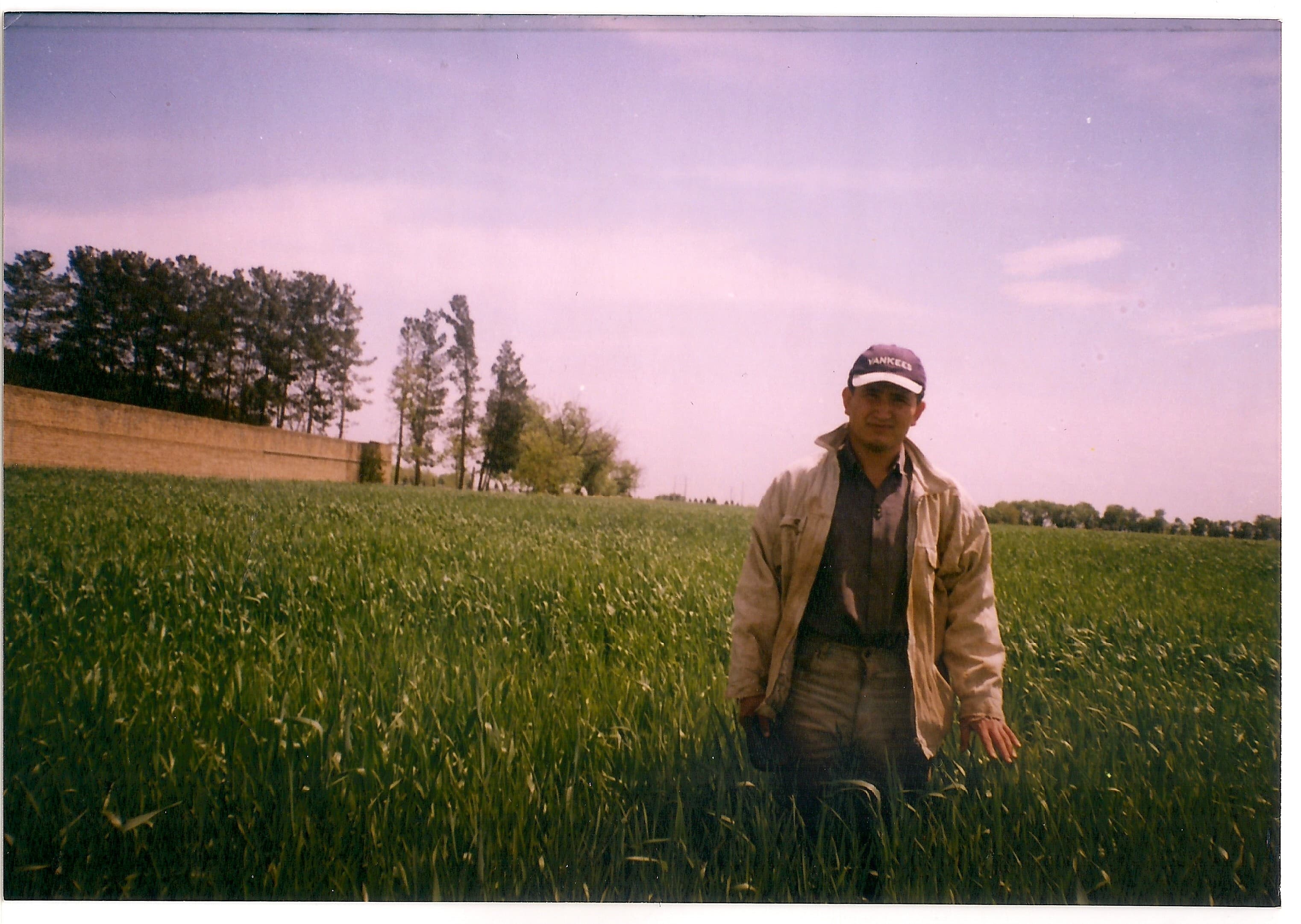 A young Mosa Rahimi standing in a field in work clothes
